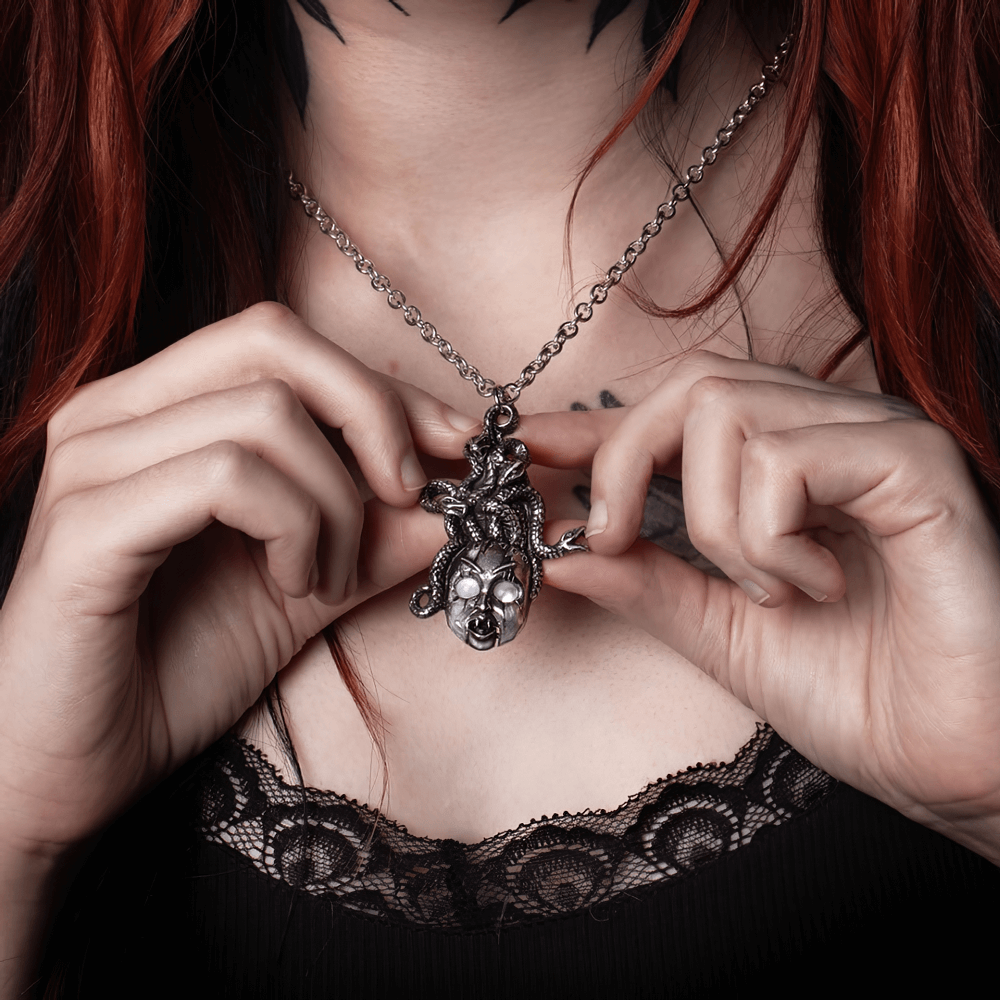 Frightening doll's head pendant with serpent hair, showcasing eerie details and a chilling jaw movement.