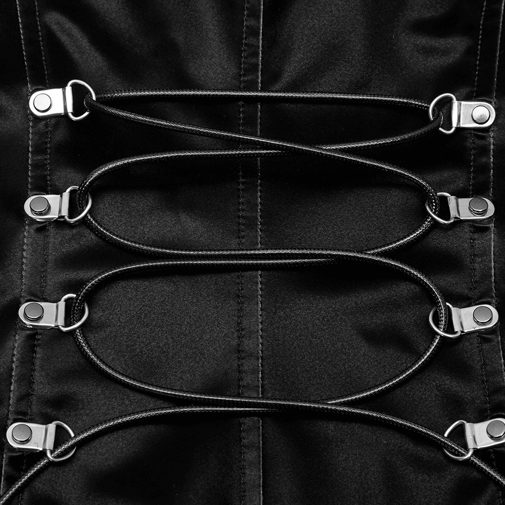 Close-up of black dress lace-up detail with shiny metallic fasteners and sleek black cords.