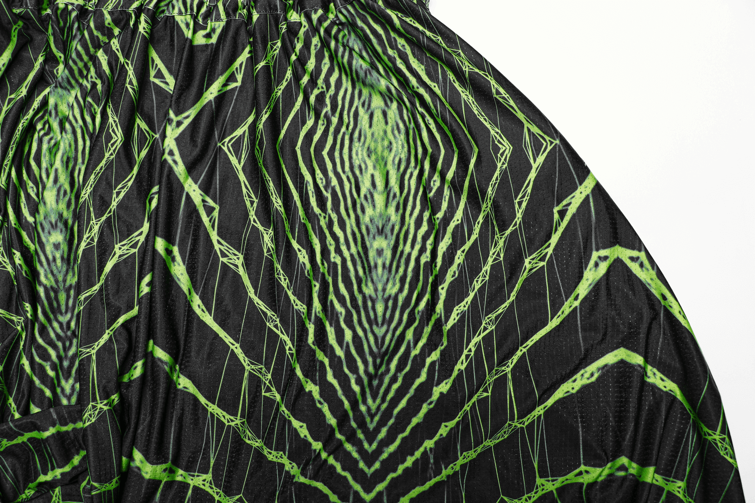 Futuristic geometric print on black harem pants with green designs, perfect for cyberpunk streetwear.