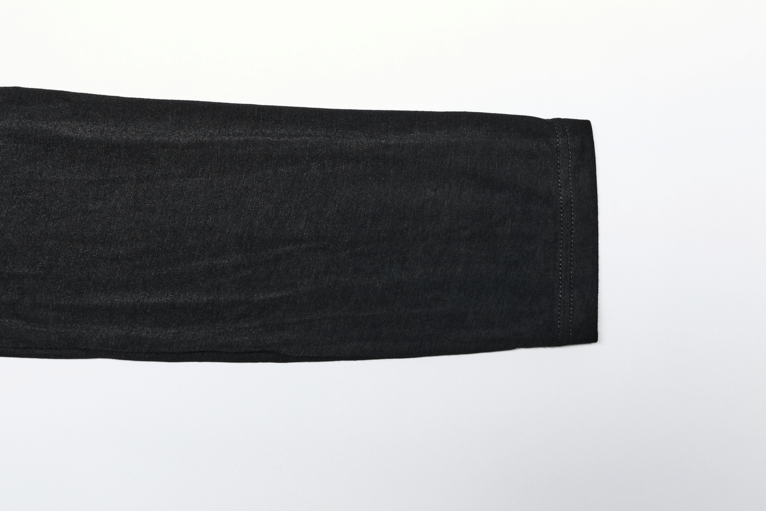 Close-up of the sleeve of black futuristic harem pants showcasing stretch-knit fabric and elastic detail.