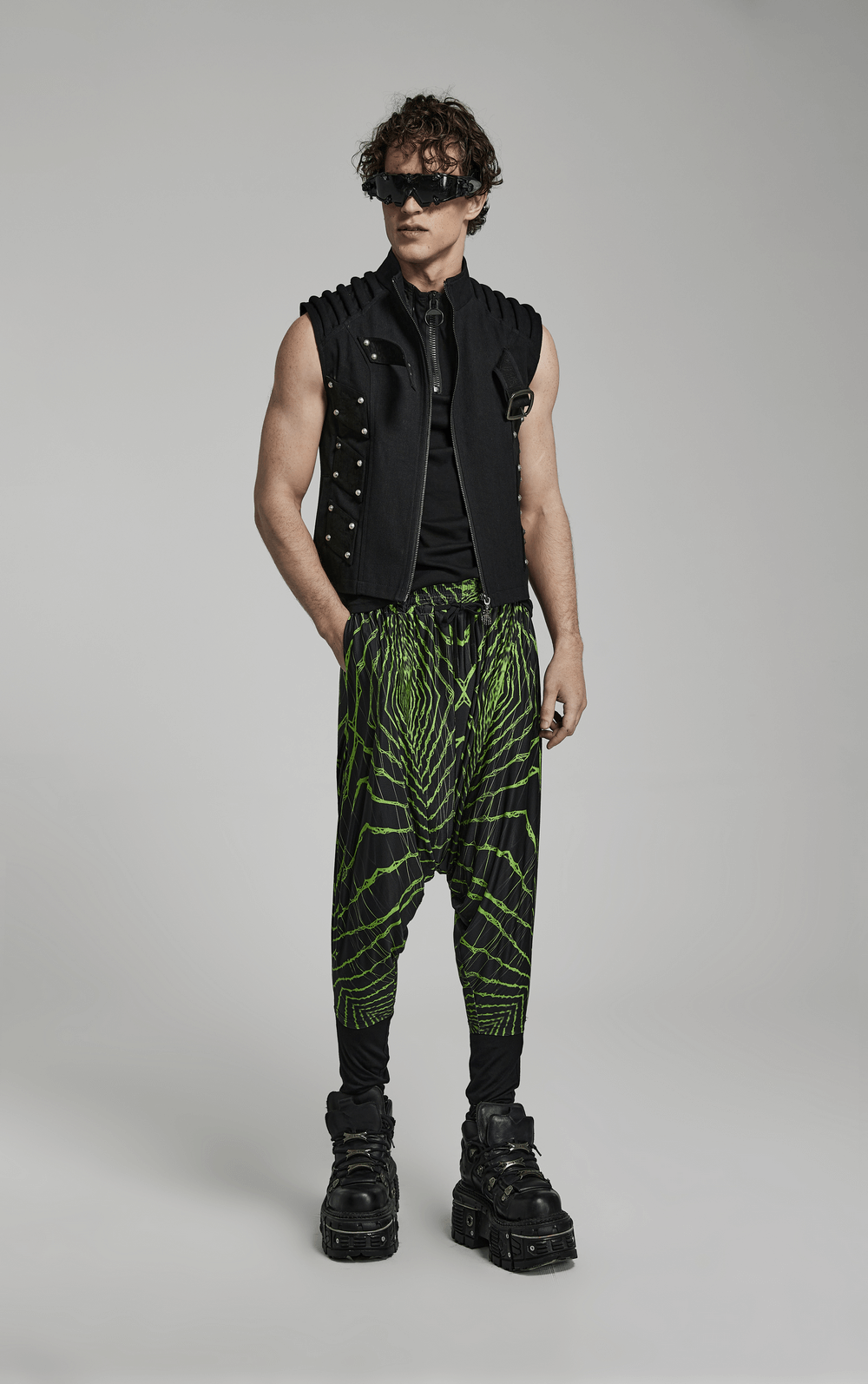 Model wearing futuristic geometric harem pants with elastic waist and a stylish vest, perfect for cyberpunk streetwear.