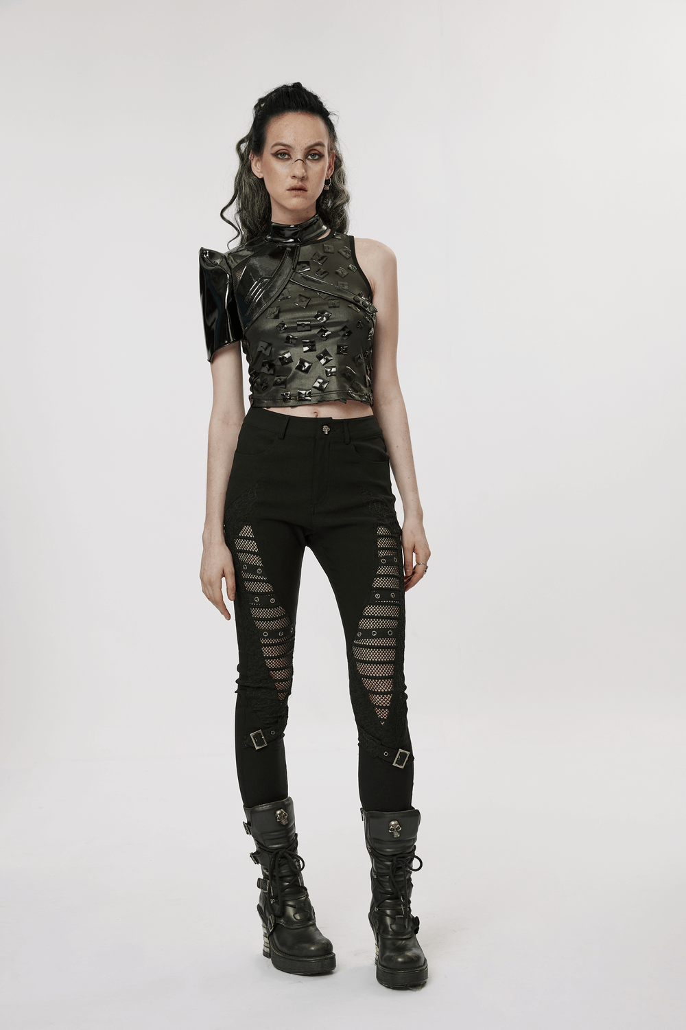Model in a futuristic one-arm glossy patent leather top and edgy black pants with mesh detailing.