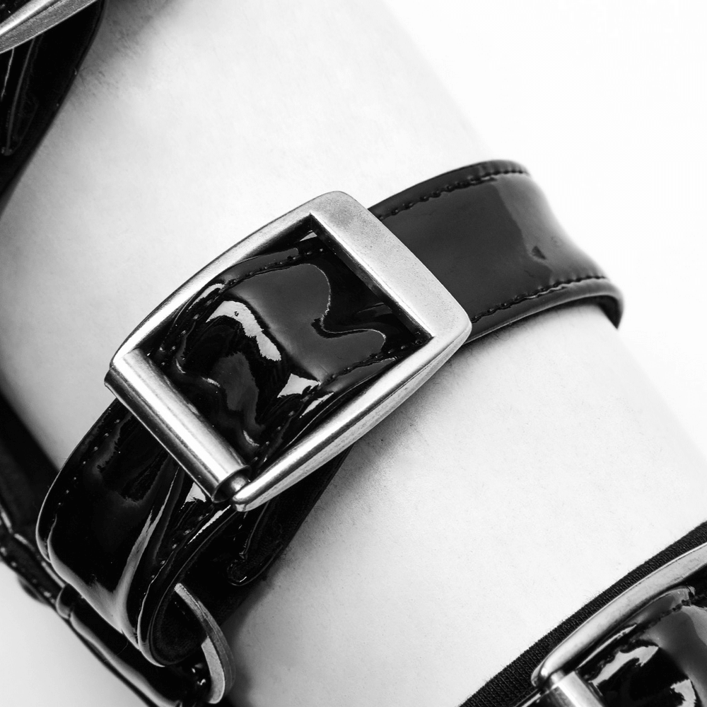 Close-up of a stylish black patent leather strap with a shiny metallic buckle, perfect for punk fashion flair.