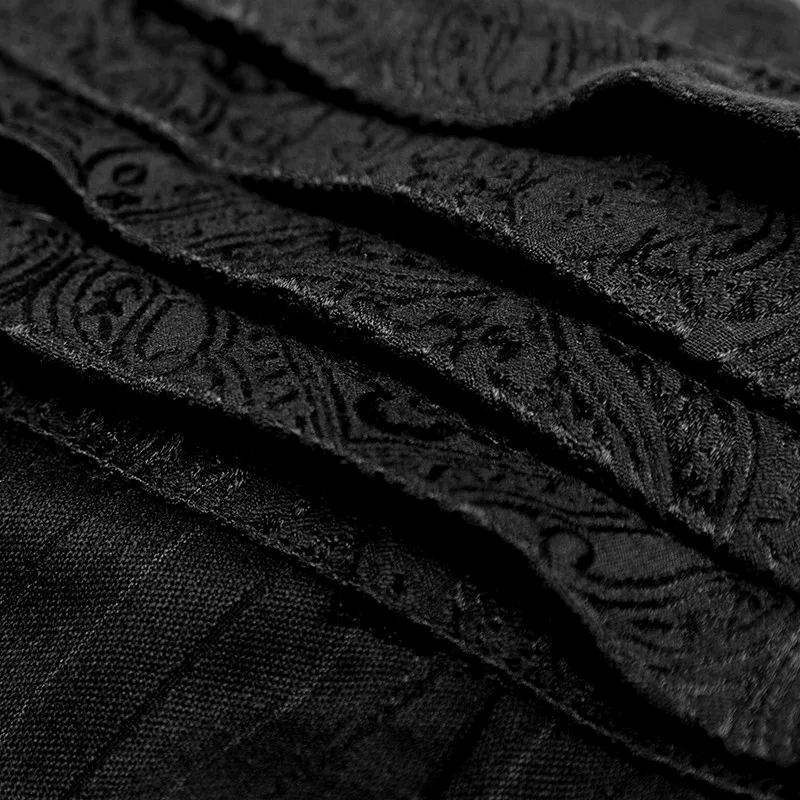 Close-up of elegant black fabric with intricate paisley patterns, perfect for steampunk fashion.