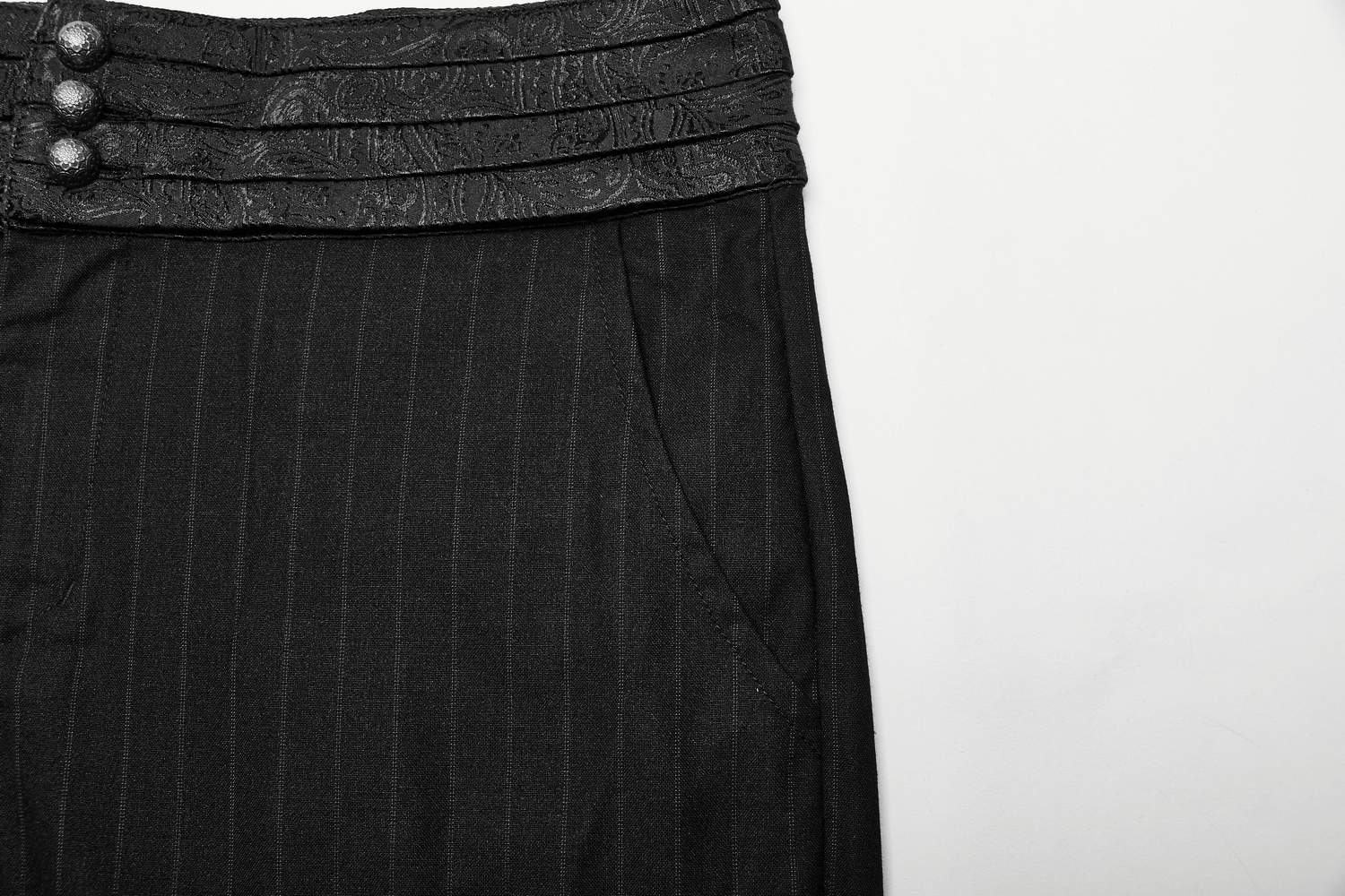 Close-up of gentleman's black striped pants featuring an elegant layered waistband and decorative buttons.