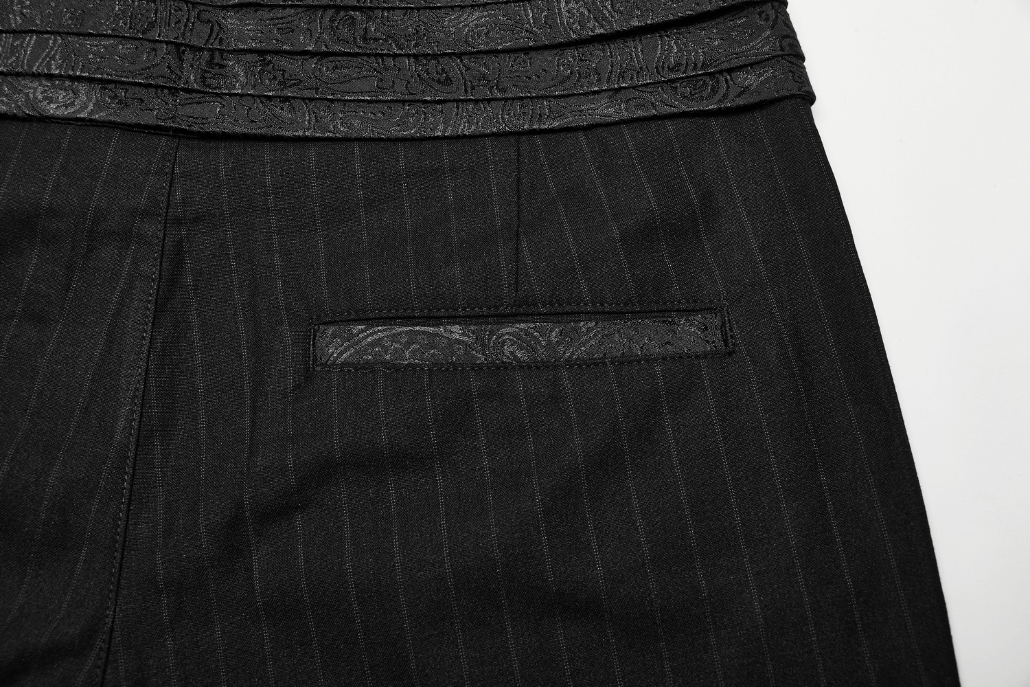 Elegant black-striped pants waistband with intricate detailing and functional pocket for a stylish steampunk look.