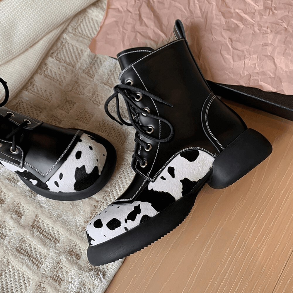Genuine leather ankle boots for women in trendy cow print with lace-up design and stylish round toe.