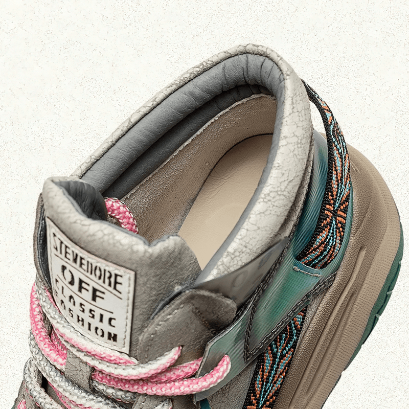 Close-up view of stylish women's patchwork platform boots with pink laces and textured leather in trendy design.