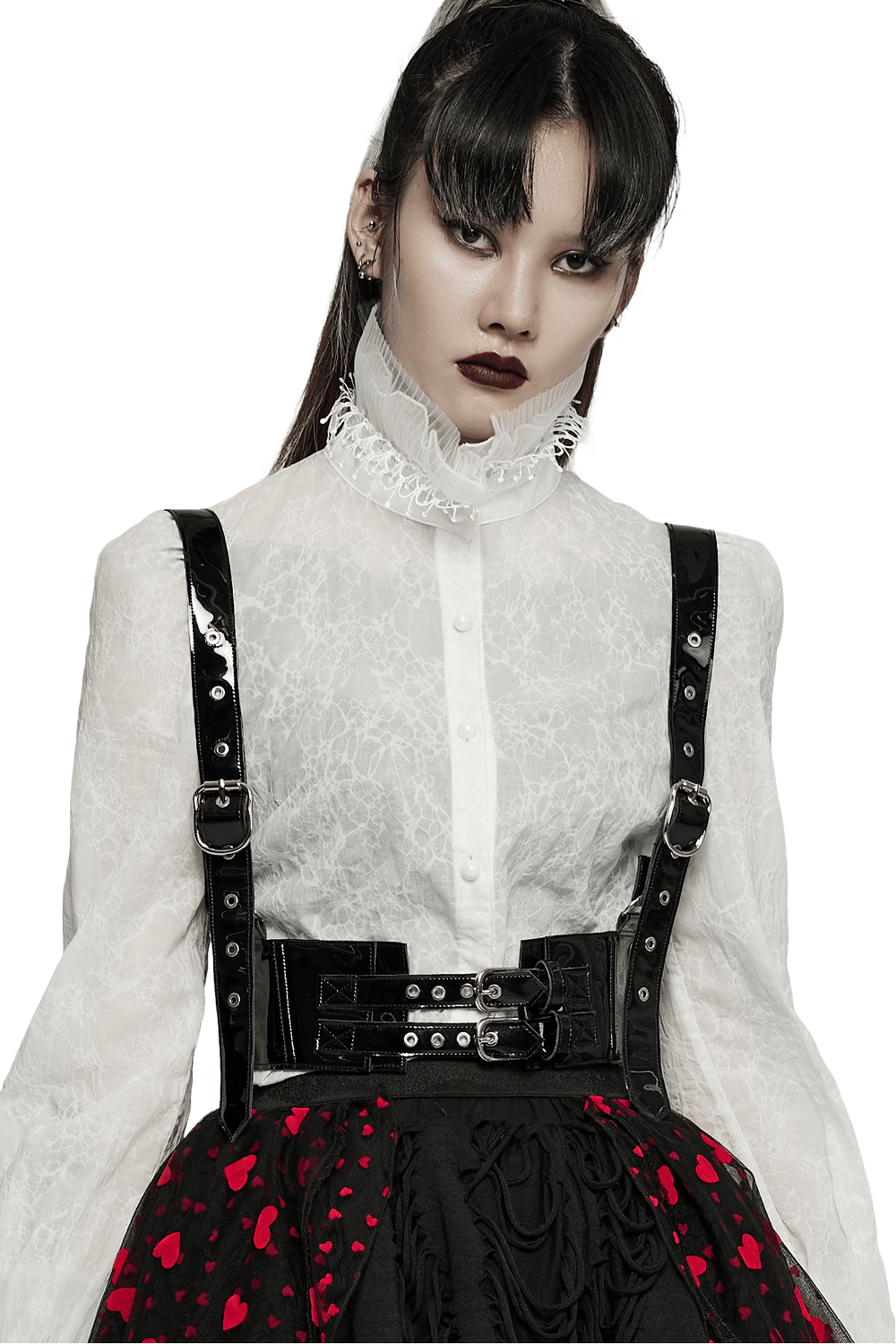 Punk fashion model wearing a glossy PU leather corset belt with metal accents and a stylish blouse.