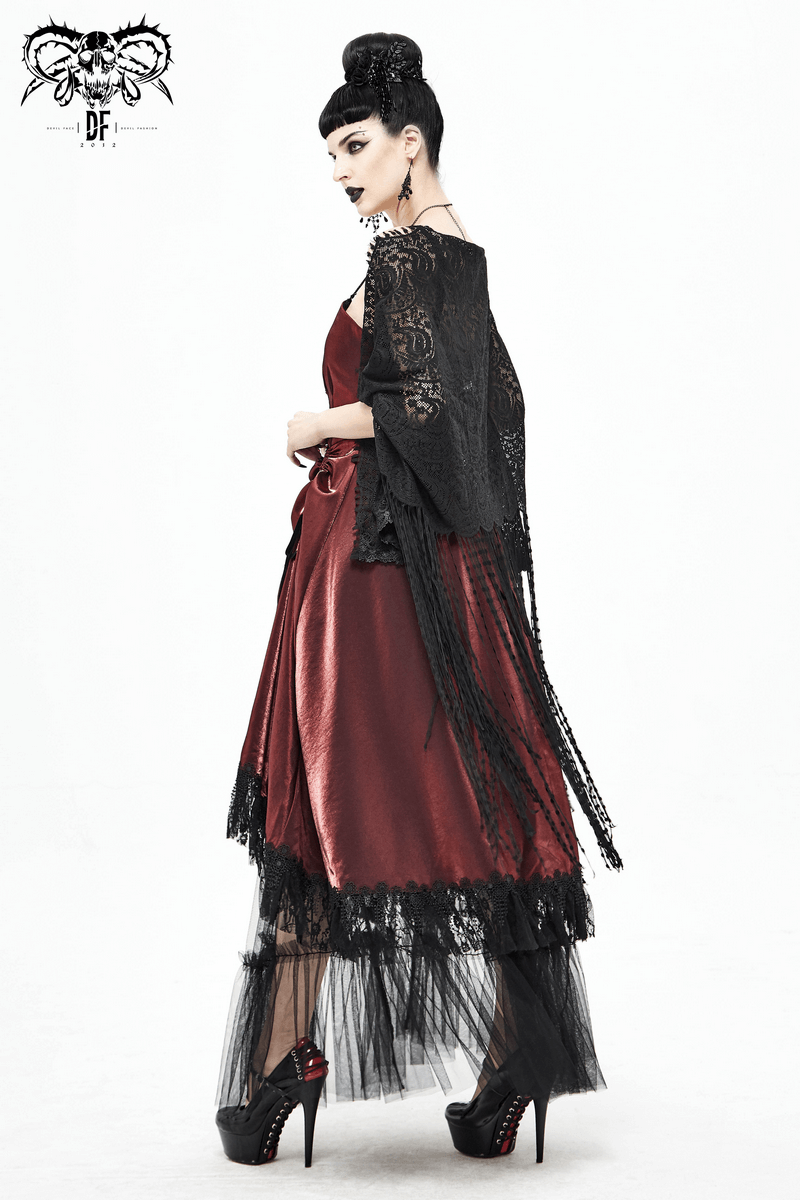 Stylish model in a black lace cape over a red satin dress, showcasing gothic elegance and fringe details.