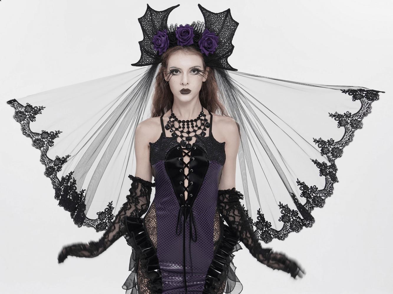 Goth Bat Wing Lace Veil Headpiece with Purple Roses worn by a model in a dramatic goth outfit.