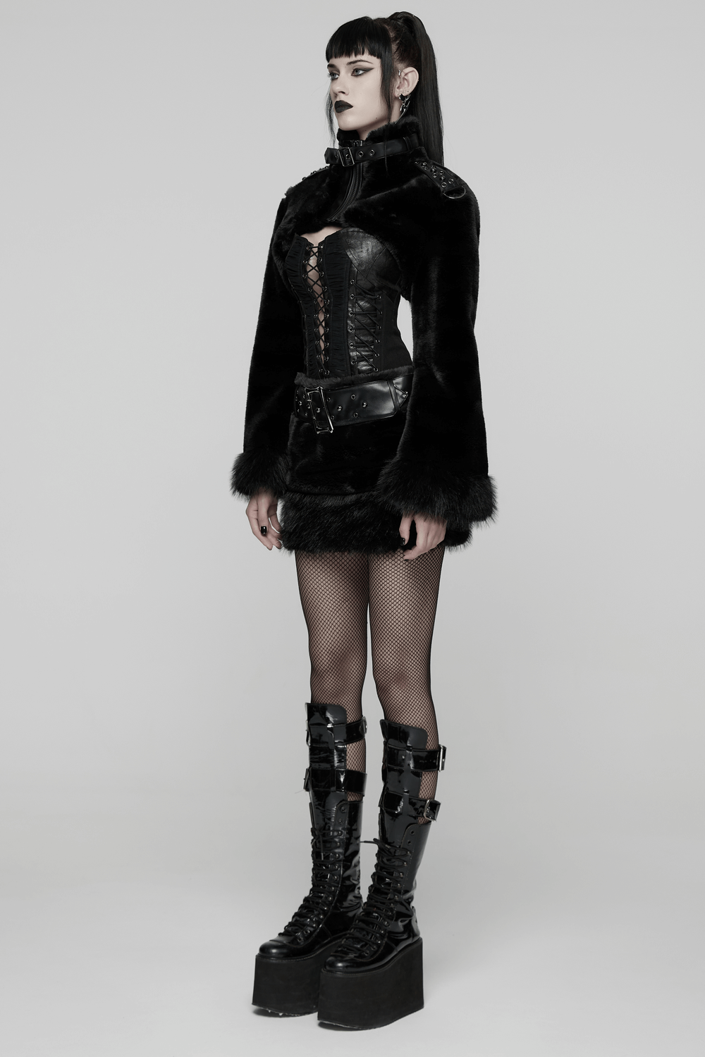Goth Black Faux Fur Mini Skirt with Studded Belt worn with edgy boots and fishnet tights, showcasing alternative fashion.
