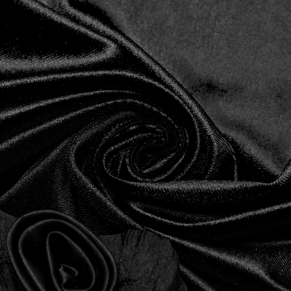 Close-up of rich black velvet fabric with soft folds, showcasing luxurious texture and elegant sheen.