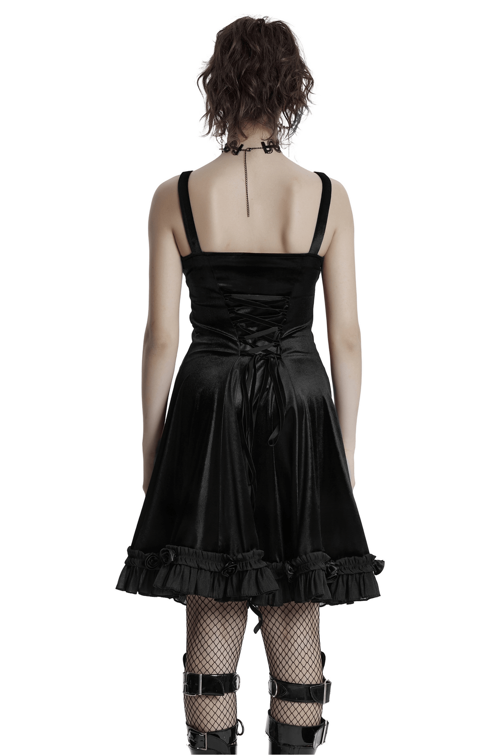 Back view of a gothic black velvet dress with lace details and a ruffled hem, paired with edgy accessories.