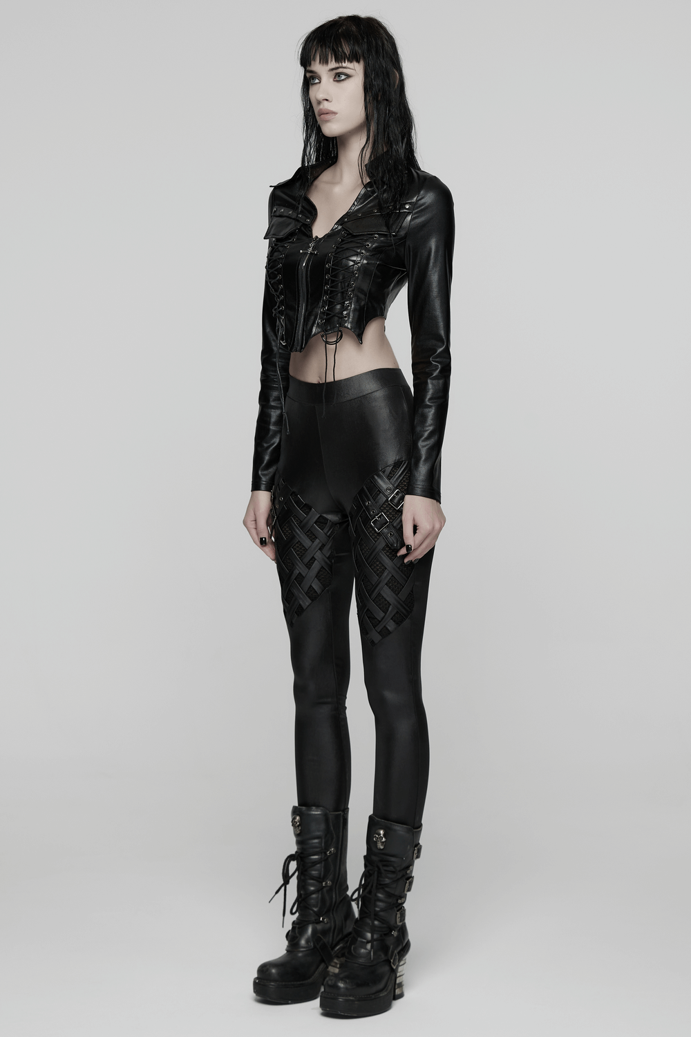 Goth Cropped Faux Leather Jacket with Rivets and Lacing worn with edgy black leggings and chunky boots.