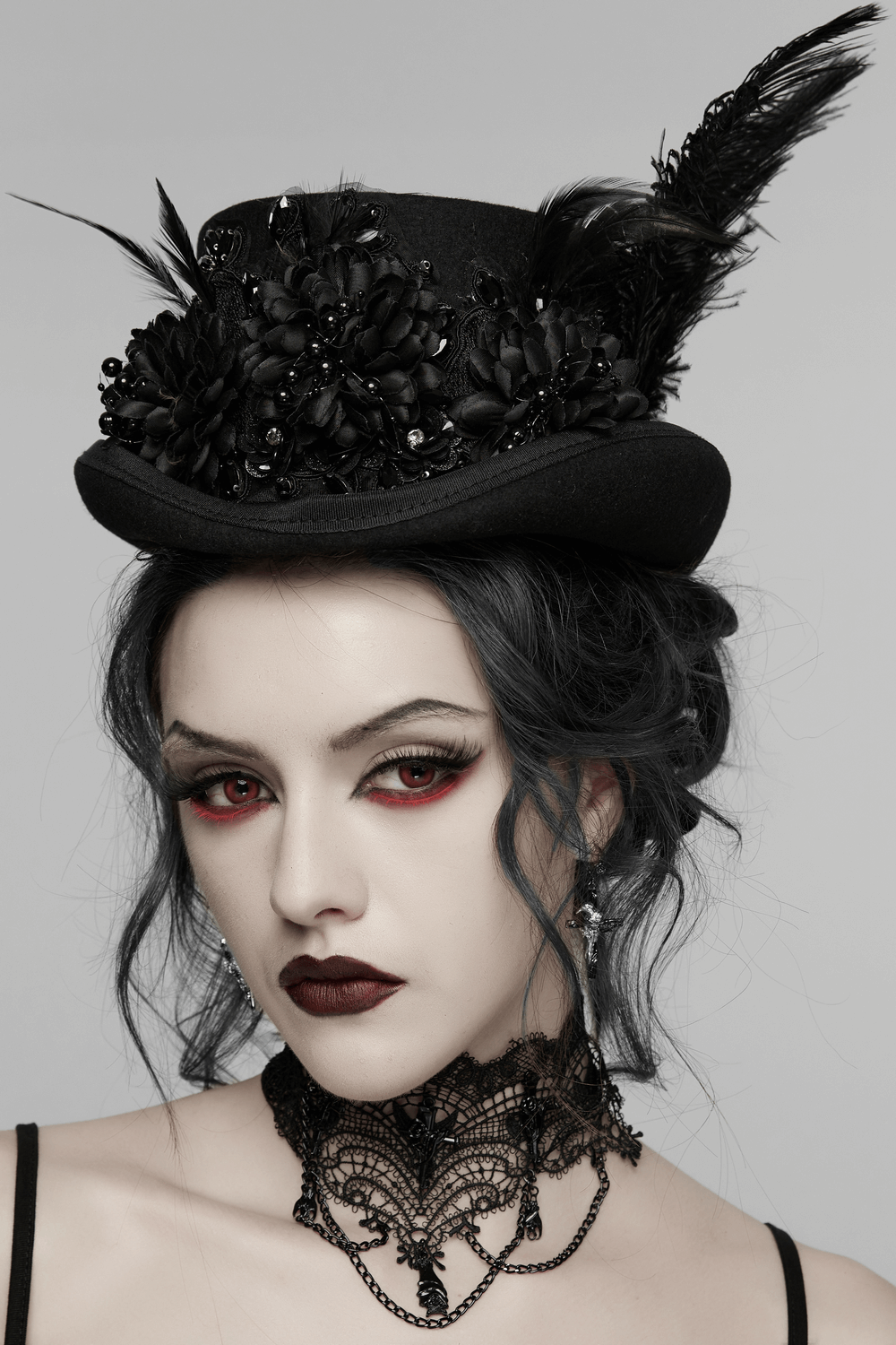 Goth Feather Floral Top Hat for Victorian Steampunk worn by a model, featuring feathers and floral details against a gray backdrop.