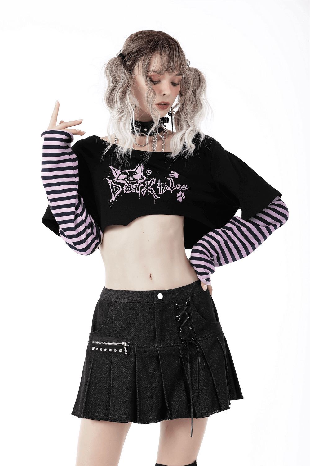 Model in Goth Punk Crop Top with Cheshire Cat graphic and striped sleeves, styled with a chic pleated skirt.