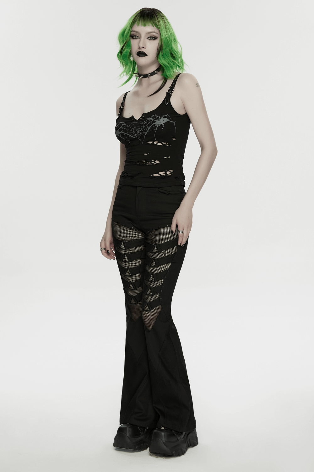 Goth Punk Mesh Flare Pants with Strap Buckle Detail worn with a ripped tank top and edgy green hair against a plain background.
