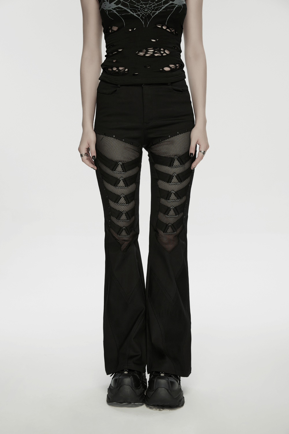 Goth Punk Mesh Flare Pants with Strap Buckle Detail worn by model with a black ripped top and sneakers.