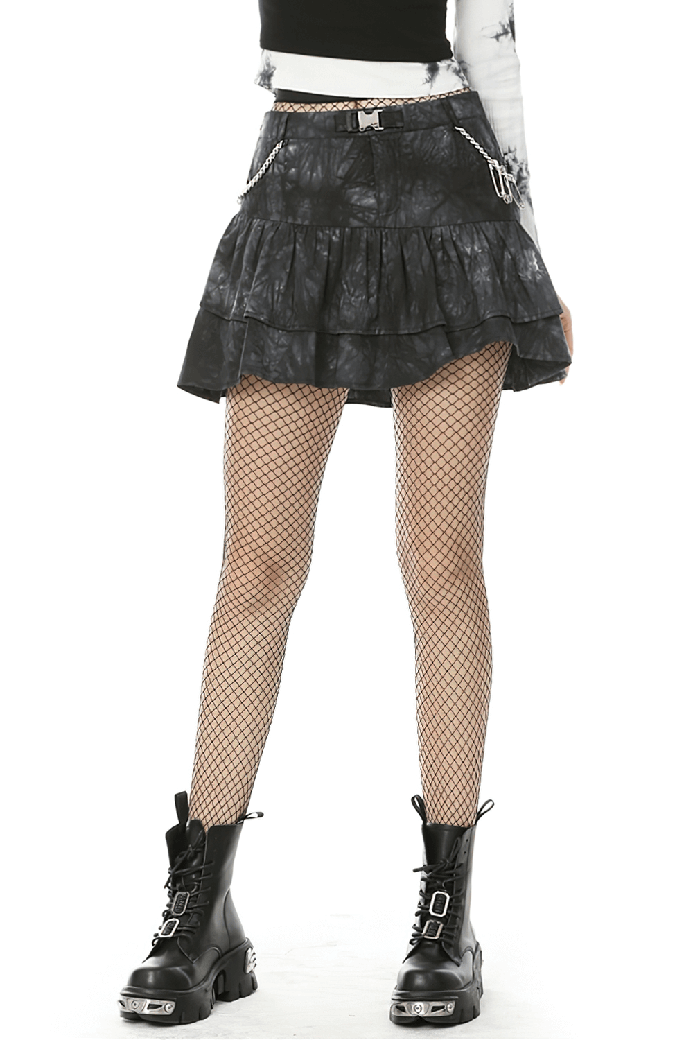 Goth women's black tie-dye mini skirt with ruffles and chains, styled with fishnet tights and combat boots.