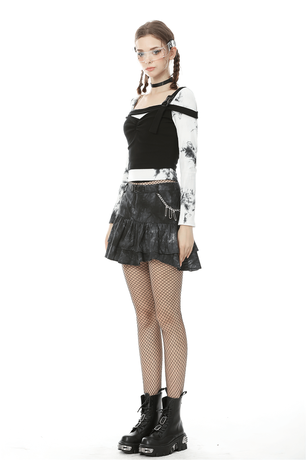 Goth women's mini skirt with ruffles and chains, styled with a band tee and combat boots for an edgy look.