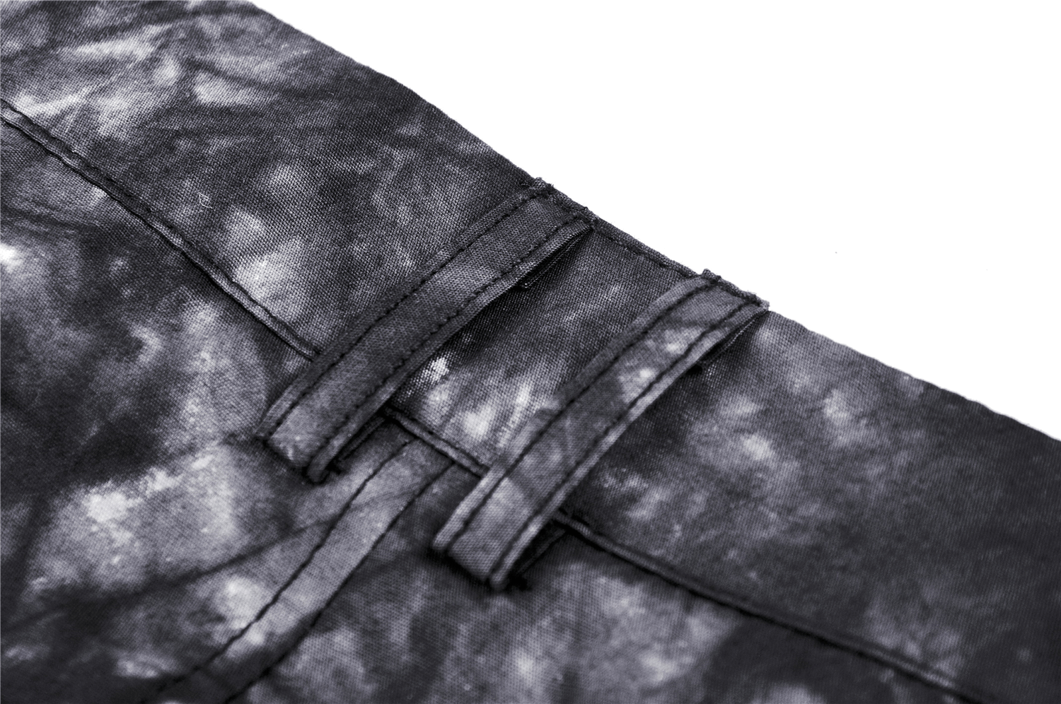 Close-up of black tie-dye fabric with ruffles and chain details for a goth mini skirt.