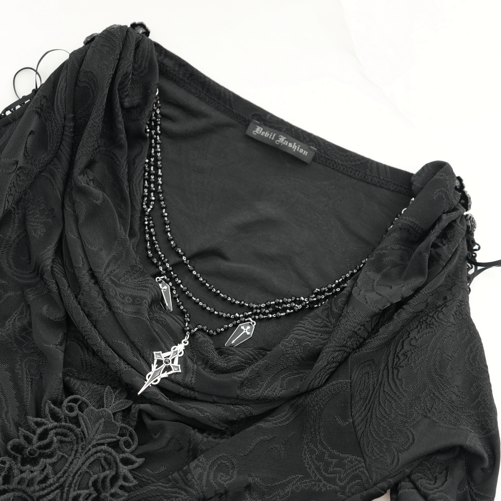 Close-up of a goth women's top with flared sleeves, lace detail, and dramatic black fabric.