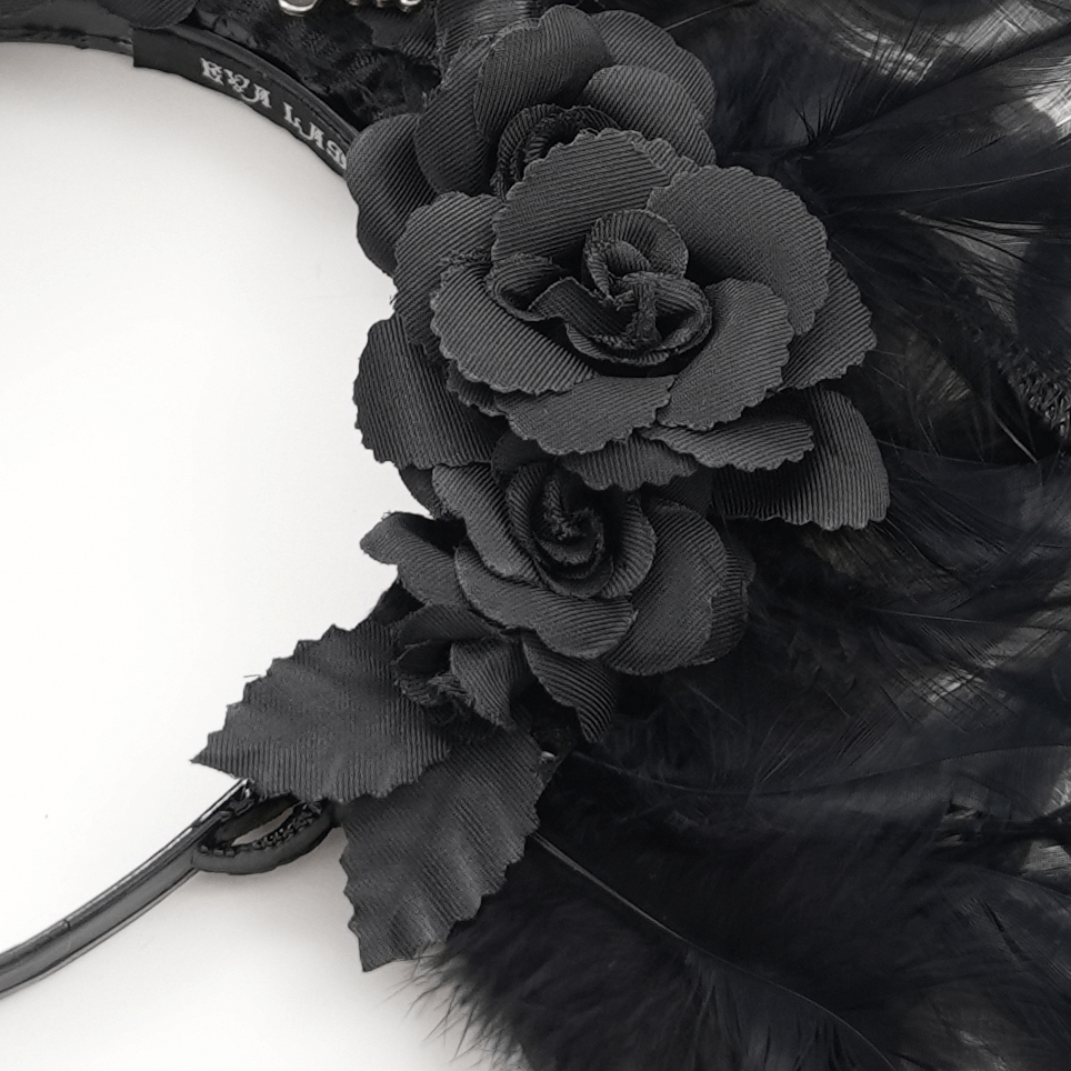Close-up of black roses on a gothic feathered headpiece, adding dark elegance and mystical allure.