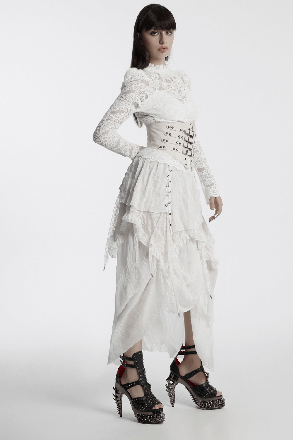 Gothic model wearing asymmetric white chiffon skirt with lace and drawstrings, paired with edgy spiked heels.