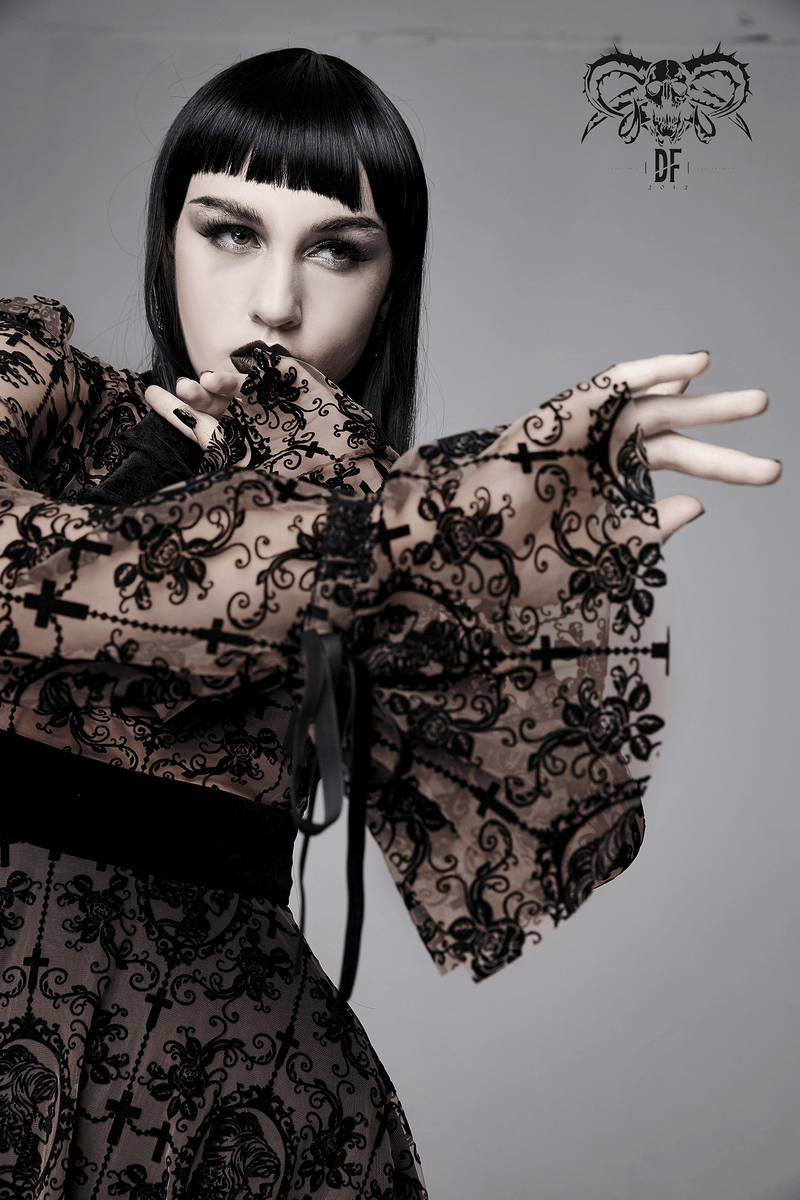 Woman in gothic lace dress with a stylish asymmetrical cut and dramatic sleeves, showcasing dark, elegant fashion.