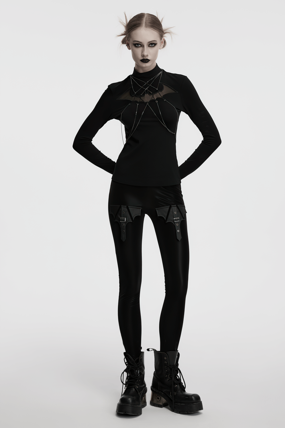 Model wearing Gothic Bat Chain Long Sleeve Top with mesh accents and chains, paired with black leggings and combat boots.