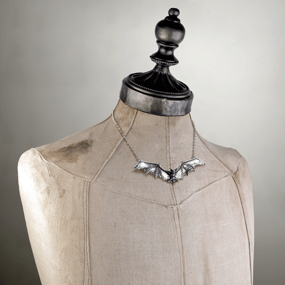 Gothic bat necklace in pewter with spread wings displayed on a mannequin, embodying dark elegance.