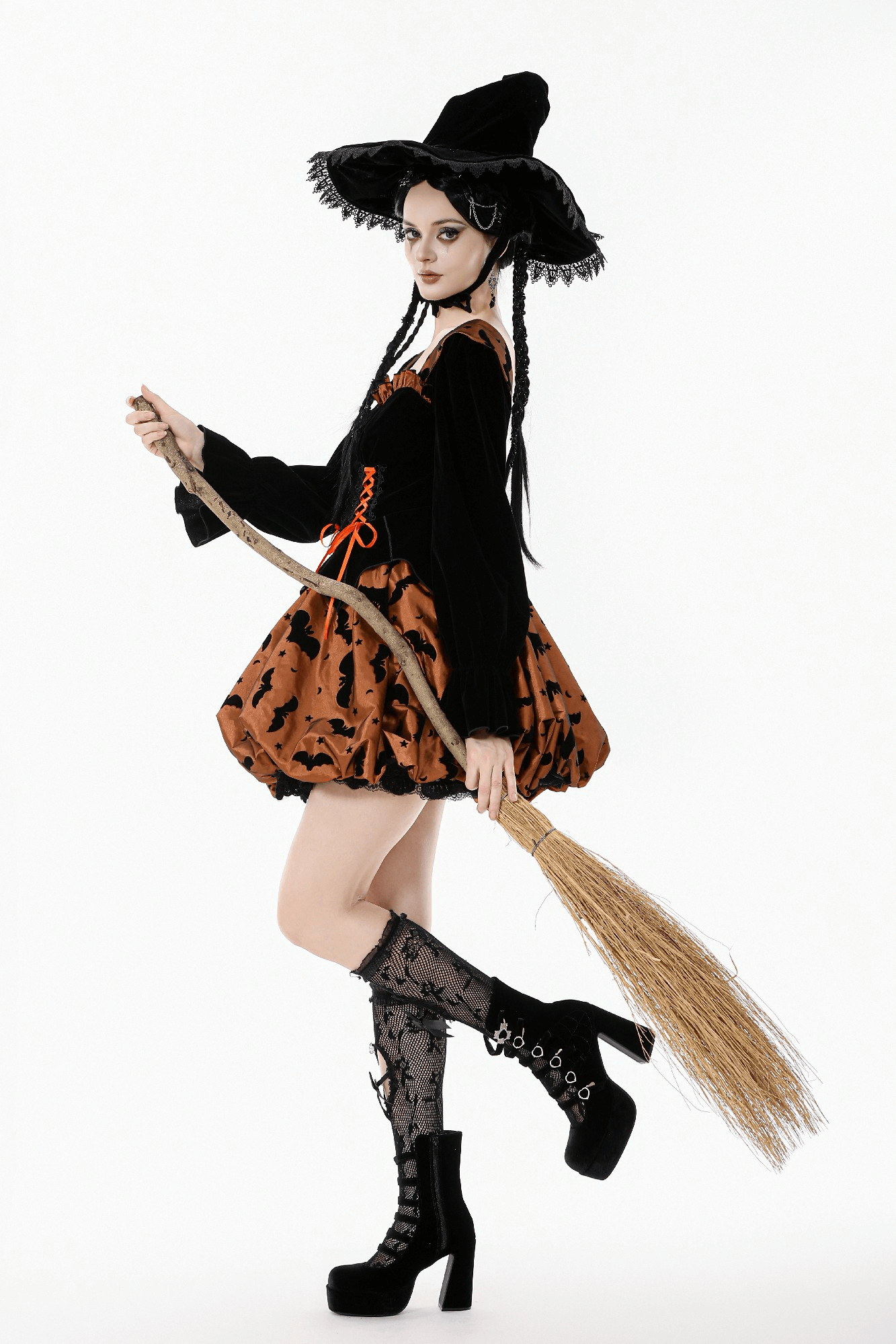 Gothic Bat Print Puff Sleeved Dress with Corset Lacing worn by model holding a broom, showcasing its whimsical style.