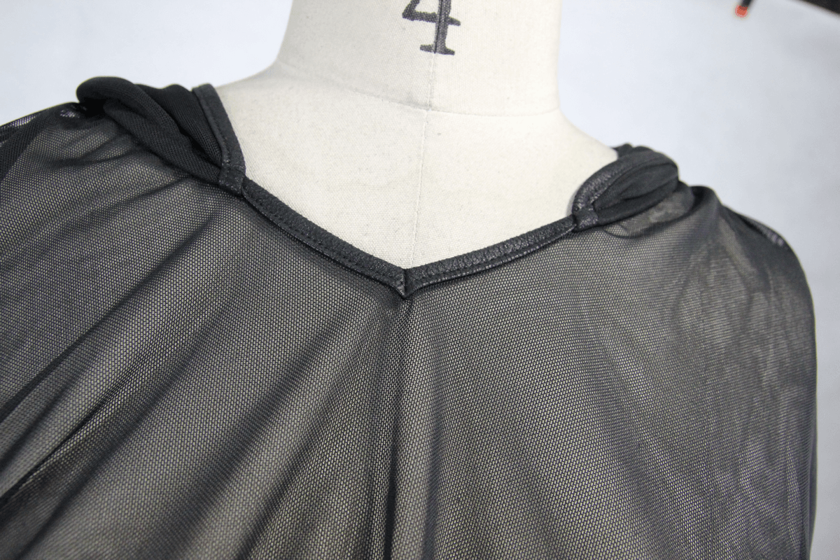 Close-up view of women's black gothic mesh cape with a hood and asymmetrical cut, showcasing fashionable details.
