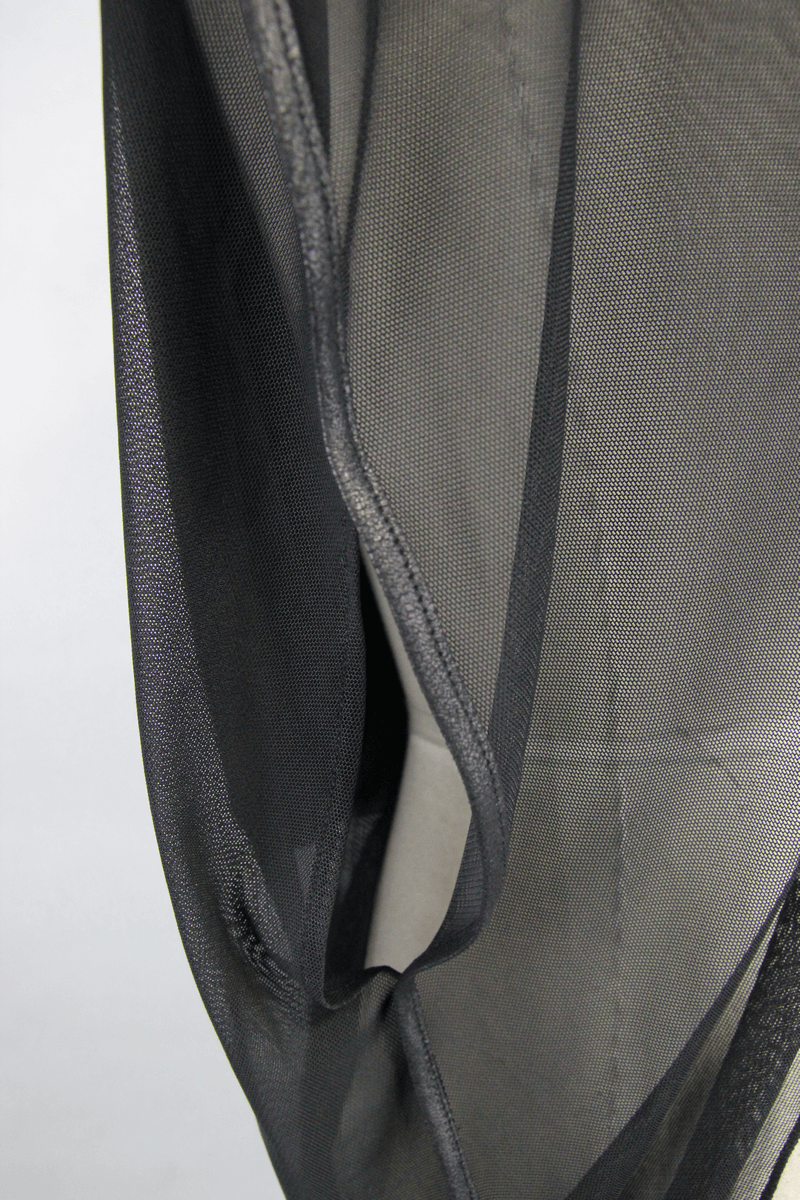 Close-up of black mesh fabric highlighting the texture and asymmetrical cut of a gothic hooded cape.