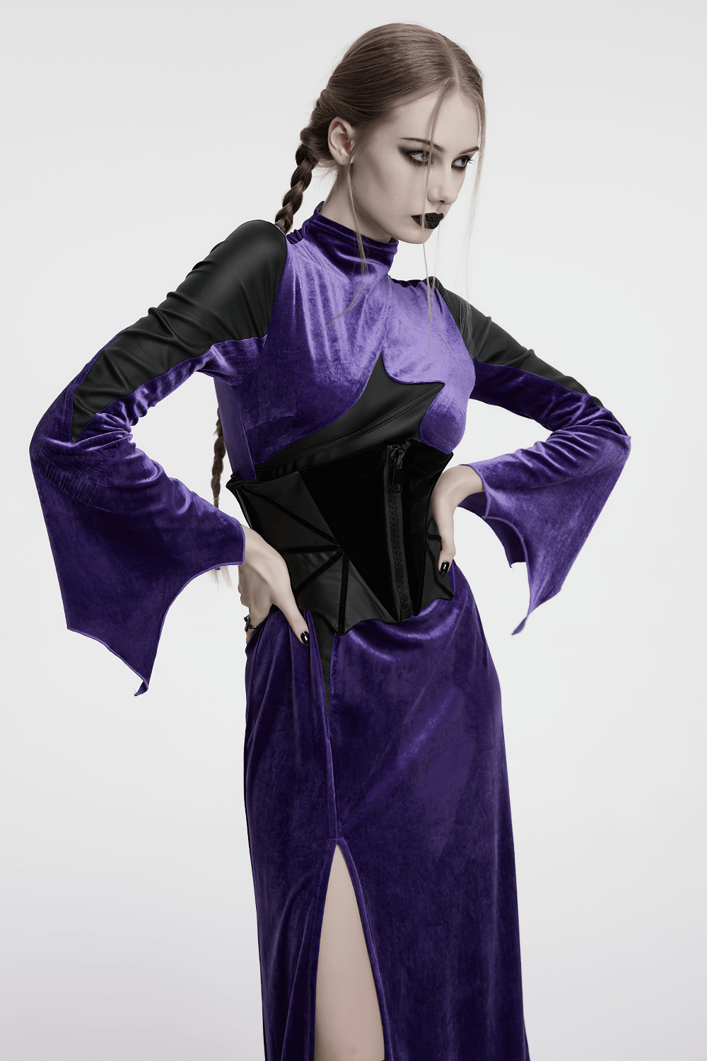 Model in purple velveteen dress wearing gothic bat corset belt with black accents and daring side slit.