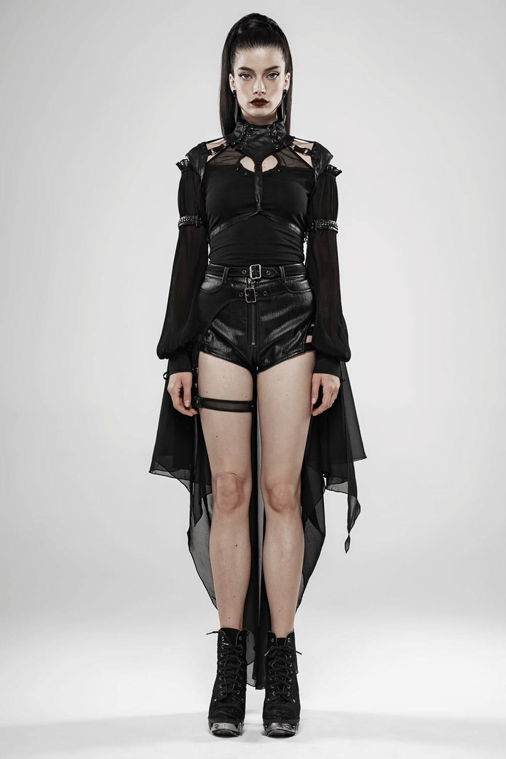 Gothic model in batwing cape, black top, and leather shorts exuding dark elegance and heavy metal vibes.