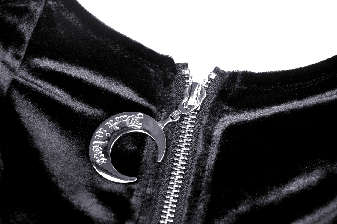 Close-up of a silver crescent moon pendant and zipper detail on a stylish black velvet batwing hoodie.