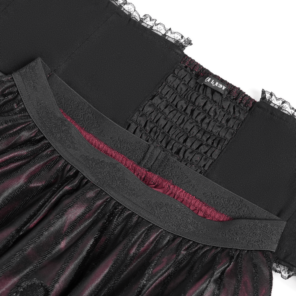 Close-up of gothic black and burgundy maxi skirt waistband with lace and buckle detail, showcasing pleated texture.