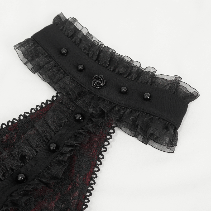 Close-up of gothic black and red off-shoulder top with lace details and decorative black buttons.