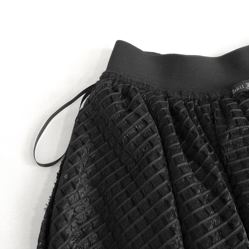 Close-up of black gothic skirt detailing, showcasing textured fabric and waistband for bold fashion statement.