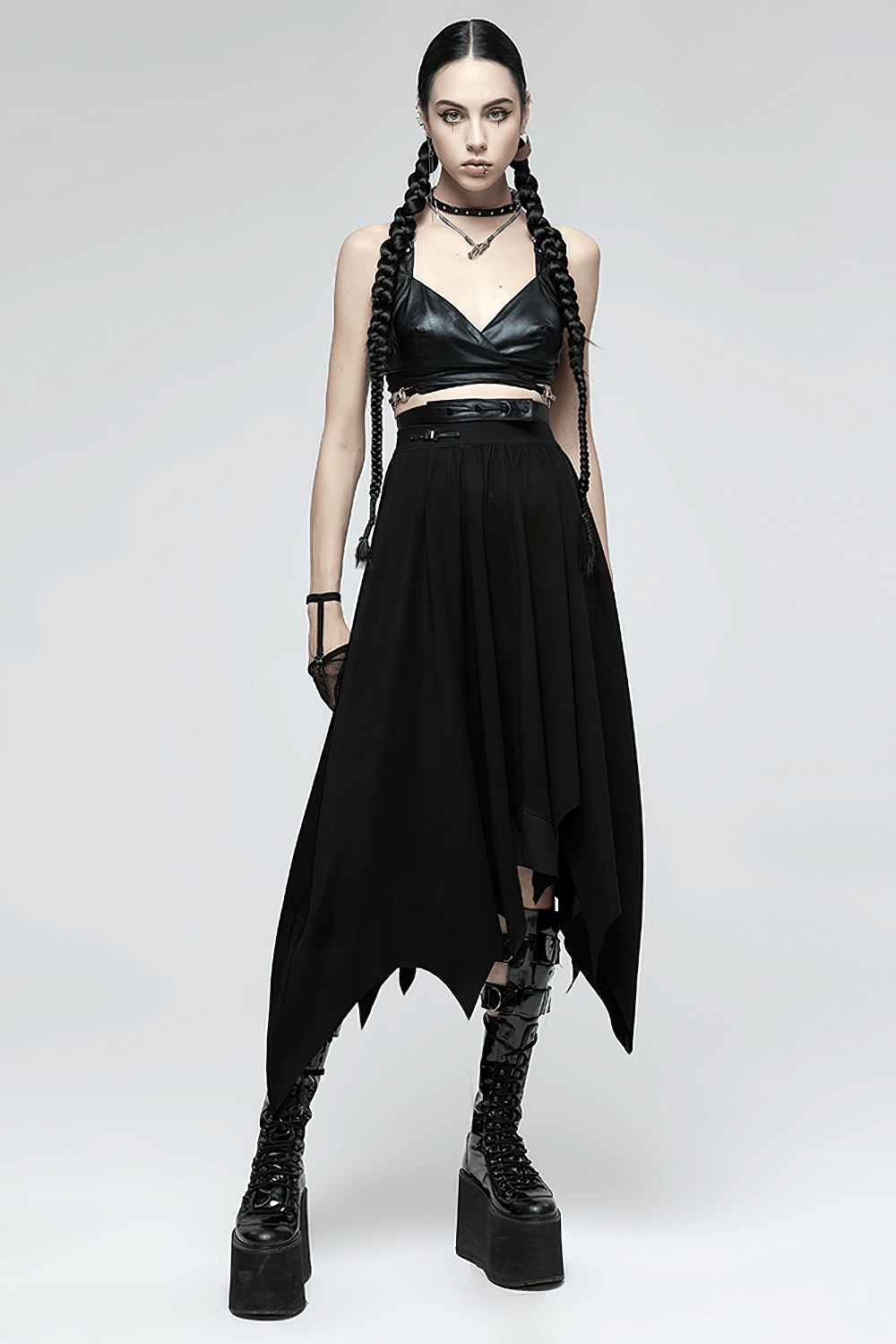Gothic black asymmetrical long skirt with buckle waist, styled with edgy crop top and platform boots.