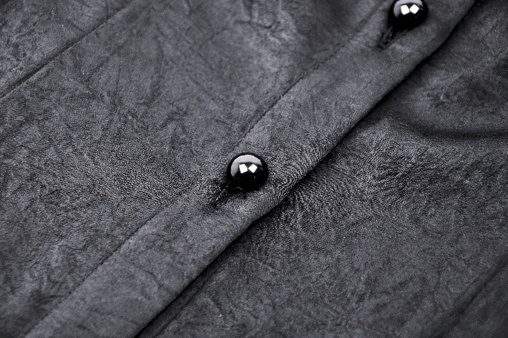 Close-up of black ruffled blouse buttons and textured fabric, showcasing Gothic Victorian style.