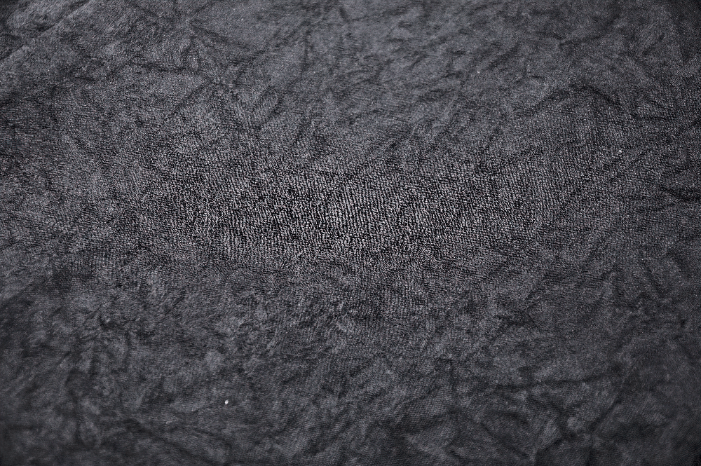 Textured close-up of dark fabric, showcasing a rich, sophisticated black ideal for gothic clothing.