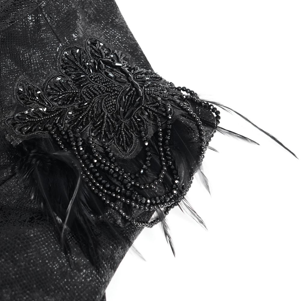 Close-up of gothic black bolero shrug with intricate lace, beads, and feather embellishments for dark elegance.