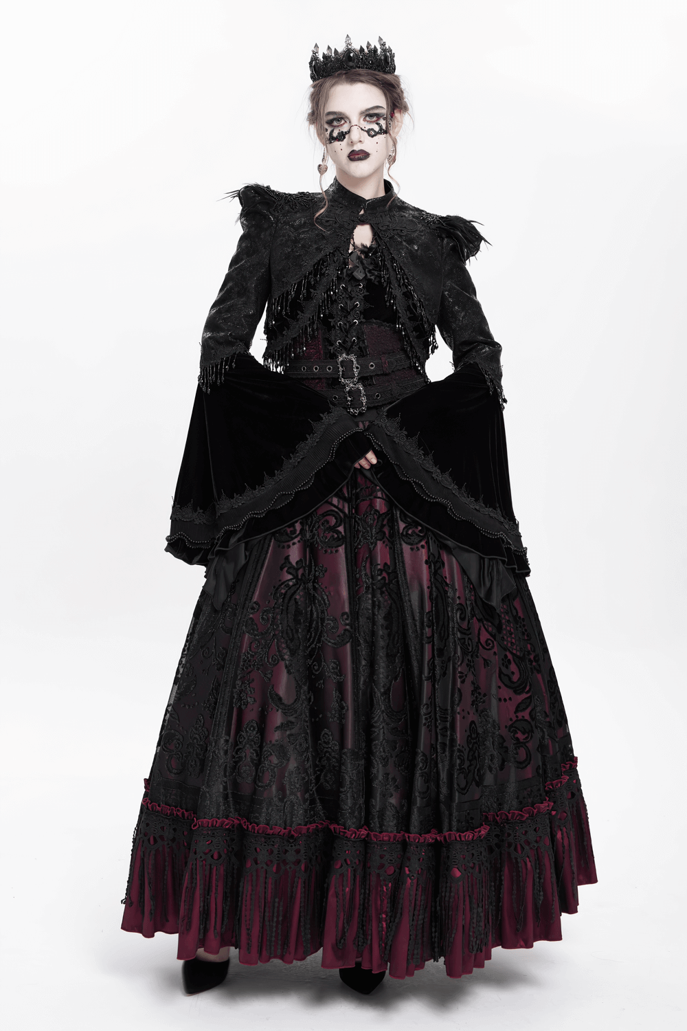 Gothic model wearing a black bolero shrug and dramatic gown with lace details and beaded bell sleeves.