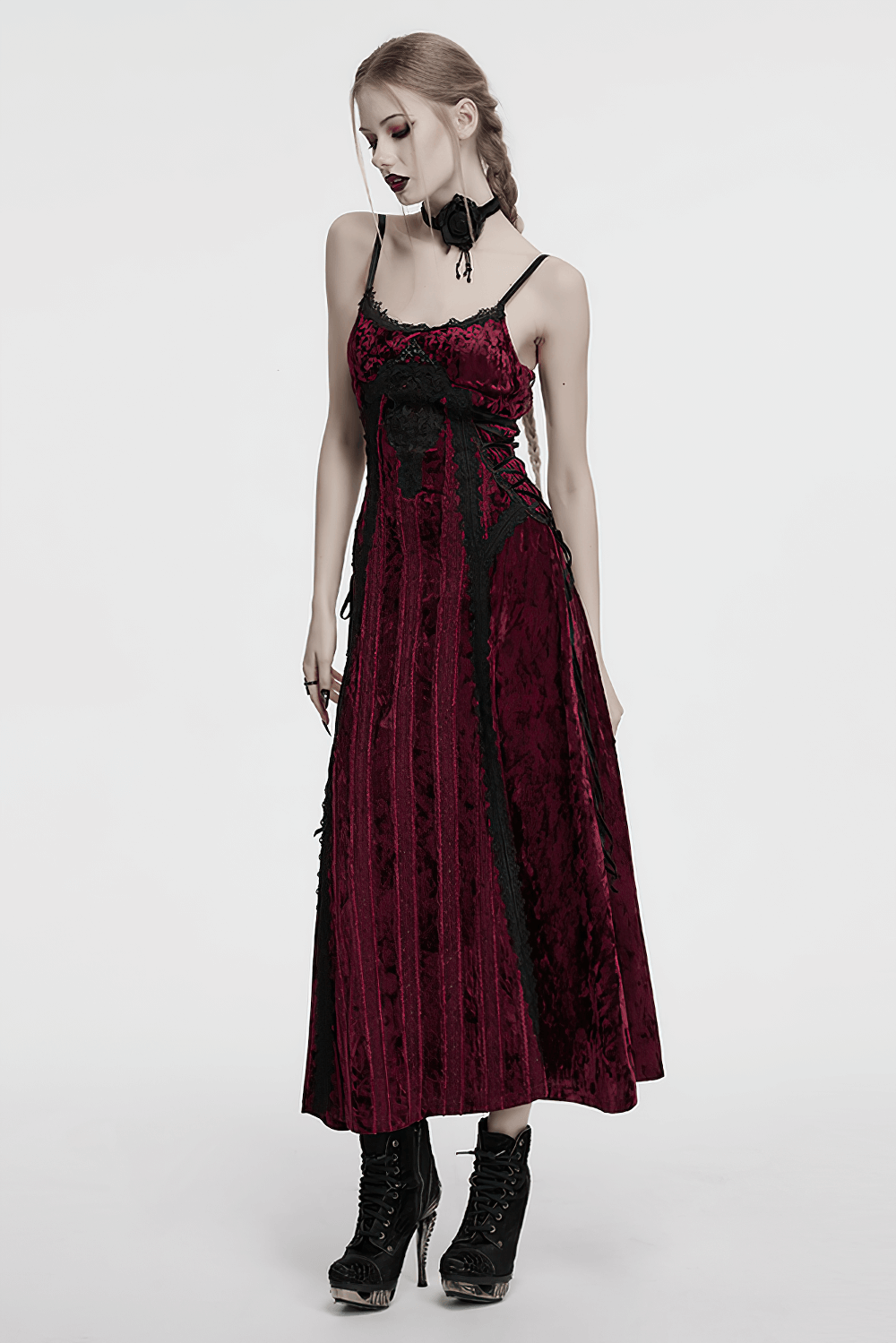 Gothic model in a long red and black velvet dress, showcasing edgy elegance and style, perfect for dramatic fashion.