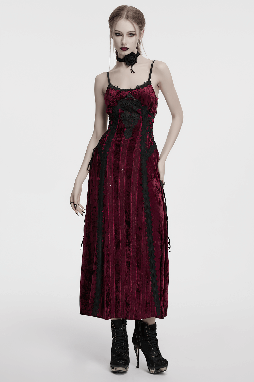Elegant goth model in a dark red velvet dress with lace details and black accents, embodying vintage gothic style.