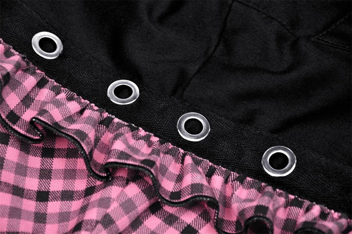 Close-up of gothic black cat ear crop top detailing with pink plaid ruffle and grommets.