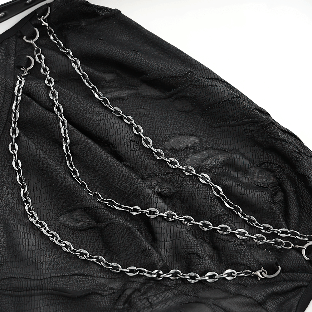 Close-up of gothic black halter top featuring edgy chain embellishments on distressed fabric.